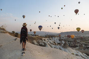 Junge Frau und Heißluftballons am Abend, Goreme, Kappadokien, Türkei - KNTF03304