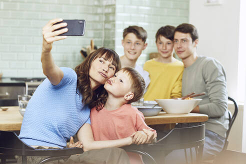 Mutter und ihre vier Söhne machen Smartphone-Selfies beim Mittagessen - MCF00172