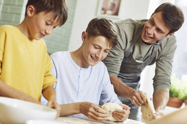 Brothers preparing pizza dough in kitchen - MCF00192