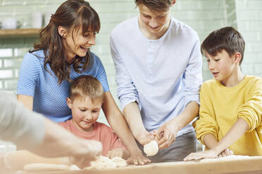 Mother and sons preparing pizza at home - MCF00194