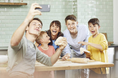 Sone macht Fotos von seiner Mutter und seinen Brüdern, die zu Hause Pizza zubereiten - MCF00196