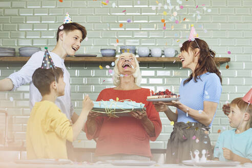 Mutter und Söhne feiern den Geburtstag ihrer Großmutter in ihrer Küche - MCF00204