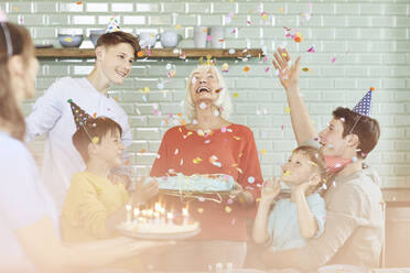 Mother and sons celebrating grandmother's bithday in their kitchen - MCF00207