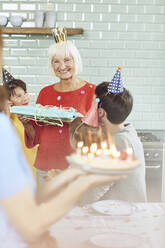 Enkelkinder feiern den Geburtstag der Großmutter zu Hause - MCF00209