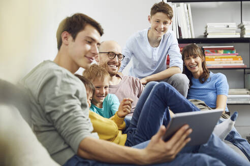 Eine große Familie, die zu Hause Spaß hat und ein digitales Tablet benutzt - MCF00235