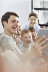 Eine große Familie, die zu Hause Spaß hat und ein digitales Tablet benutzt - MCF00237