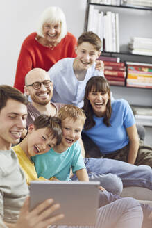 Eine große Familie, die zu Hause Spaß hat und ein digitales Tablet benutzt - MCF00238