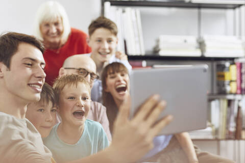 Eine große Familie, die zu Hause Spaß hat und ein digitales Tablet benutzt, lizenzfreies Stockfoto