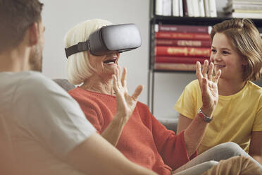 Grandmother using VR glasses with her grandsons - MCF00257