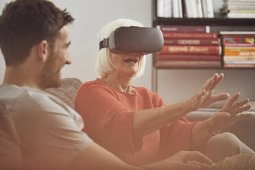 Grandmother using VR glasses with her grandson - MCF00258