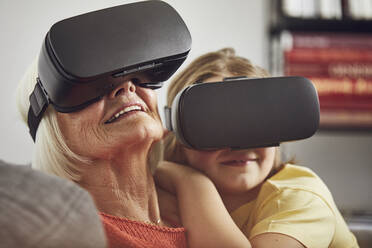 Grandmother using VR glasses with her grandson - MCF00260