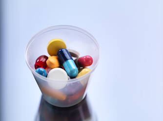 Medicine, Pills in a plastic cup - ABRF00419