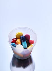 Medizin, Pillen in einem Plastikbecher - ABRF00420