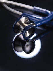 Nahaufnahme eines Stethoskops, das sich auf einem Tisch im Krankenhaus spiegelt - ABRF00426