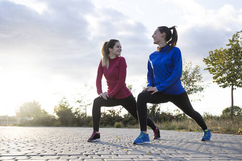 Frauen strecken ihre Beine im Park aus, lizenzfreies Stockfoto