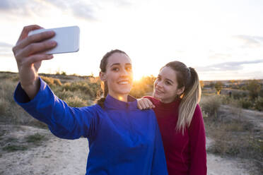 Junge Frauen in Sportkleidung machen Selfie mit Smartphone - ABZF02558