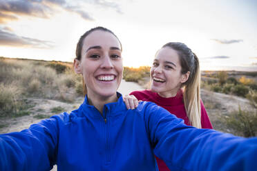 Junge Frauen in Sportkleidung machen Selfie mit Smartphone - ABZF02560