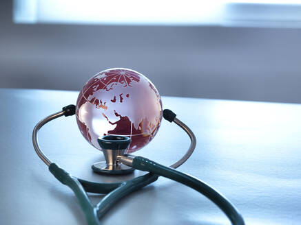 Global Healthcare, ein Glasglobus und ein Stethoskop - ABRF00432
