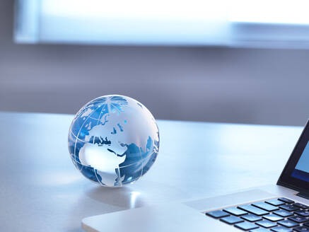 Global Markets, A glass globe with a laptop - ABRF00433