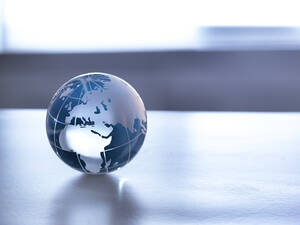 Globale Märkte, Ein Glasglobus, der die Welt auf einem Schreibtisch darstellt. - ABRF00434