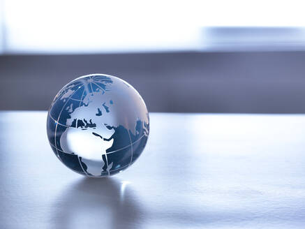 Global Markets, A glass globe illustrating the world on a desk. - ABRF00434