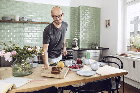 Mann deckt den Frühstückstisch, lizenzfreies Stockfoto