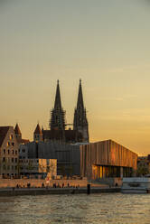 Saint Peter's Cathedral and Museum Brandhorst by Danube river against sky at sunset, Regensburg, Germany - LBF02676