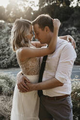 Affectionate bride and groom hugging outdoors - LHPF00742