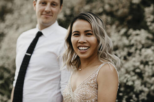 Portrait of happy bride and groom outdoors - LHPF00756