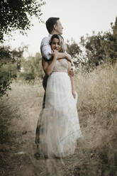 Affectionate bride and groom in the countryside - LHPF00766