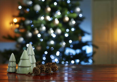 Close-up of small Christmas trees with pine cones on wooden table