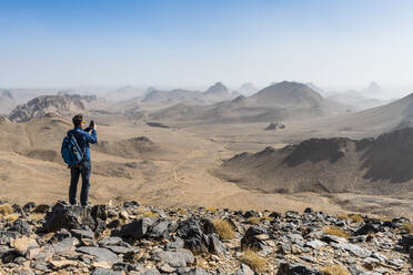 Man enjoying the mounains of Assekrem, Tamanrasset, Hoggar mountains, Algeria, North Africa, Africa - RHPLF07084