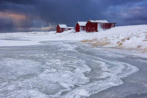 Dramatischer Himmel über typischen Fischerhäusern namens Rorbu im Winter, Eggum, Lofoten, Arktis, Norwegen, Europa - RHPLF07386