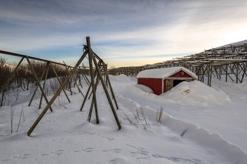 Neuschnee umgibt Kabeljaustationen und Fischerhäuser im Winter, Lofoten, Arktis, Norwegen, Europa, lizenzfreies Stockfoto