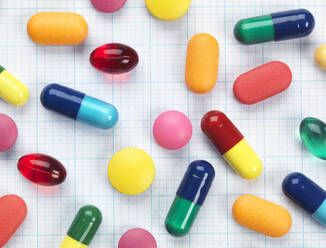 High angle view of various colorful medicines on graph paper - ABRF00469