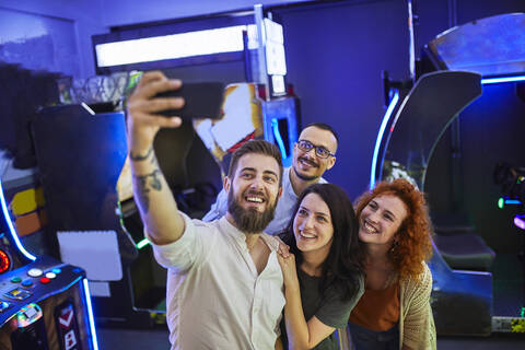 Glückliche Freunde machen ein Selfie in einer Spielhalle, lizenzfreies Stockfoto