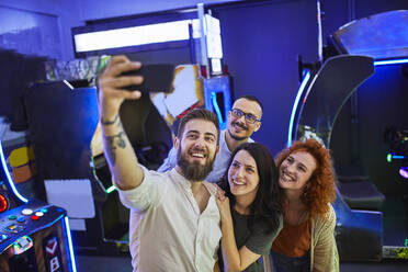 Glückliche Freunde machen ein Selfie in einer Spielhalle - ZEDF02591