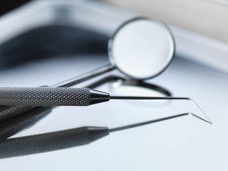 Nahaufnahme einer Parodontalsonde mit angewinkeltem Spiegel in einem Tablett im Krankenhaus - ABRF00499
