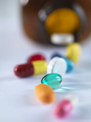 A variety of drugs falling from a medicine bottle. - ABRF00507