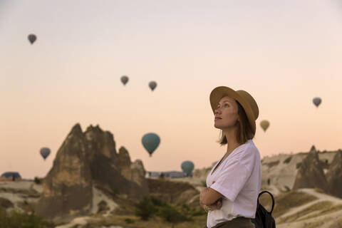 Junge Frau und Heißluftballons, Goreme, Kappadokien, Türkei, lizenzfreies Stockfoto