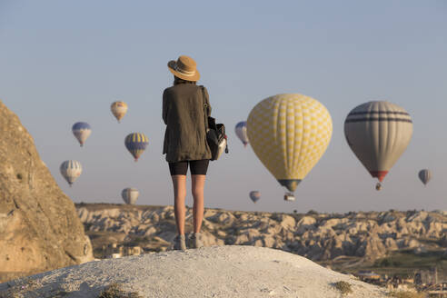 Young woman and hot air ballons, Goreme, Cappadocia, Turkey - KNTF03325
