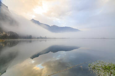 Berge spiegeln sich in der Morgendämmerung im Wasser, Pozzo di Riva Novate, Mezzola, Chiavenna-Tal, Lombardei, Italien, Europa - RHPLF07470