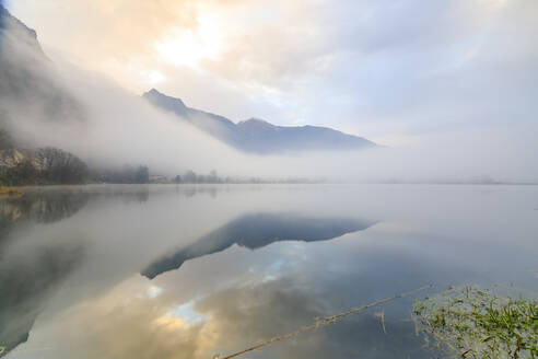 Berge spiegeln sich in der Morgendämmerung im Wasser, Pozzo di Riva Novate, Mezzola, Chiavenna-Tal, Lombardei, Italien, Europa - RHPLF07470