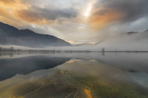 Berge spiegeln sich in der Morgendämmerung im Wasser, Pozzo di Riva Novate, Mezzola, Chiavenna-Tal, Lombardei, Italien, Europa, lizenzfreies Stockfoto