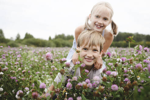 Two smiling children on clover field - EYAF00406