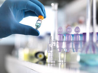 Cropped hand of scientist holding chemical formula in vial at laboratory - ABRF00546