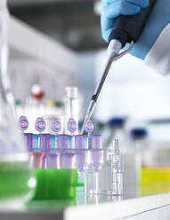 Cropped hand of scientist pipetting DNA samples into vials for experiment in laboratory - ABRF00548