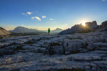 Rückansicht eines Jungen in einer Landschaft vor blauem Himmel bei Sonnenuntergang, Venetien, Italien - LOMF00890