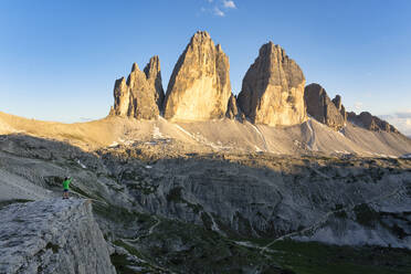 Rear view of boy looking at Tre Cime Di Lavaredo against blue sky, Veneto, Italy - LOMF00892