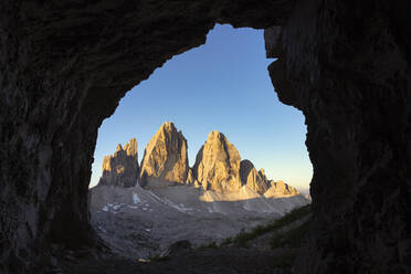 Blick auf die Drei Zinnen gegen den klaren Himmel durch eine Höhle, Venetien, Italien - LOMF00900